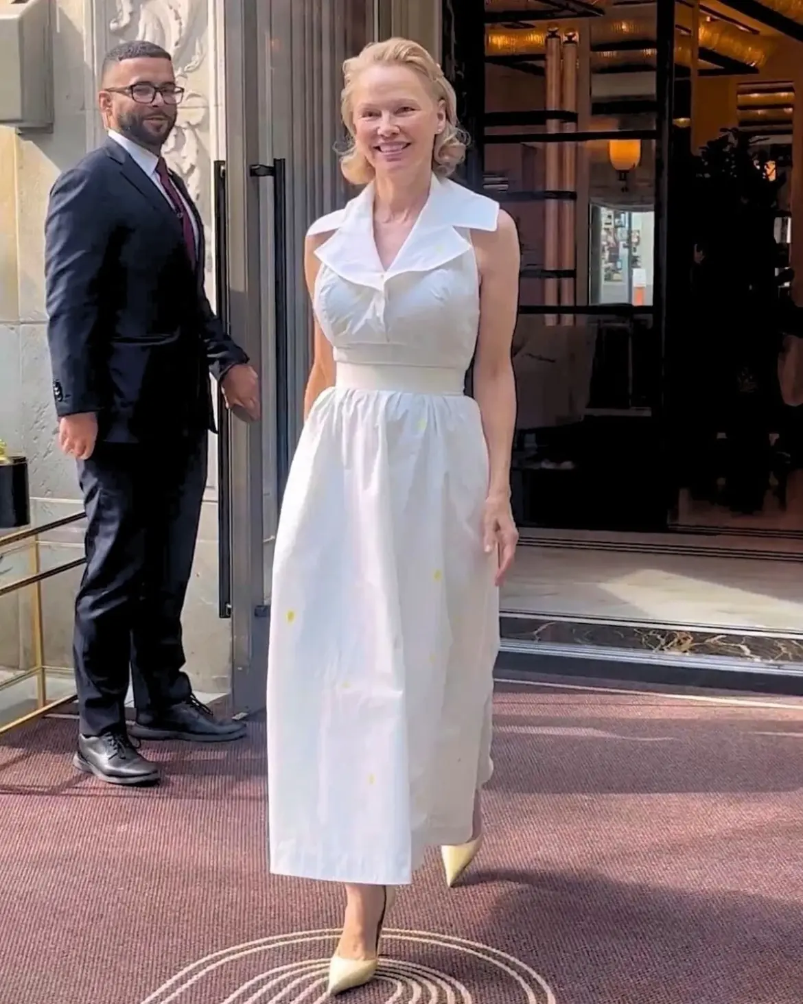 Pamela Anderson Stuns in White Dress Outside NYC Hotel 07-30-25